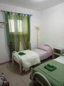 奥斯图尼Villa Gardenia的一间卧室设有两张床和一张带绿床单的桌子。