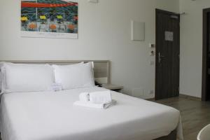 都灵都灵理工大学最佳品质酒店的卧室配有带毛巾的大型白色床