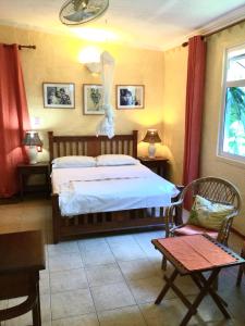 拉戈莱特拉莱因克里奥尔酒店的卧室配有一张床和一张桌子及椅子