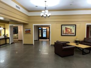 格里利Quality Inn and Conference Center Greeley Downtown的客厅配有沙发和桌子