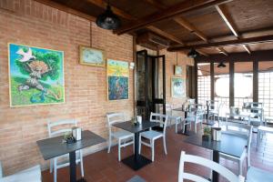 锡耶纳Hotel Arcobaleno Siena的一间带桌椅的餐厅以及砖墙