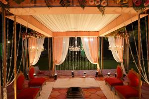 斋浦尔Stardom Resort Jaipur的一间设有红色椅子和窗帘的舞台的房间