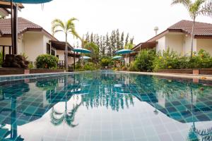 纳仲天Pinnacle Grand Jomtien Resort and Beach Club - SHA Extra Plus的部分房屋前的游泳池