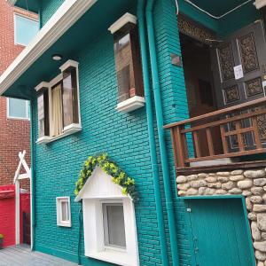 首尔Batwo Stay - For foreigners only的蓝色的房子,设有门和阳台