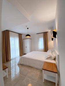 切什梅Amber Boutique Hotel的卧室配有白色的床和2扇窗户。