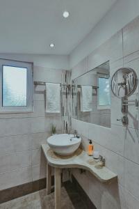 古厄庇道鲁斯Sunny Garden Aparthotel的白色的浴室设有水槽和镜子