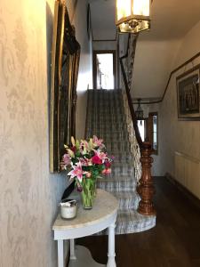 普里茅斯Wisteria house的楼梯旁边的桌子上花瓶