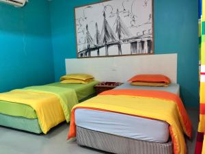 珍南海滩WAN'S ROOMSTAY LANGKAWI的两张带彩色床罩的床