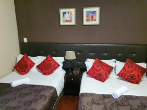 约翰内斯堡霍顿宾馆的两张位于酒店客房的床,上面有红色枕头