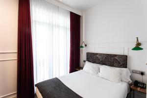 圣塞瓦斯蒂安Hotel Trueba的卧室配有白色的床和窗户。