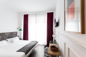 圣塞瓦斯蒂安Hotel Trueba的酒店客房配有一张床铺和一张桌子。