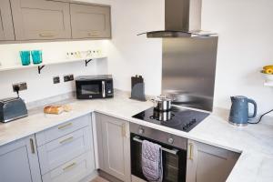 布里斯托Parkway House - Modern with great transport links的厨房配有白色橱柜和炉灶烤箱。