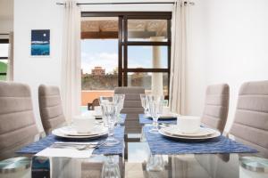 科拉雷侯FTV Holidays Homes的一间带桌椅和窗户的用餐室