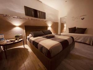 布林迪西La piazzetta的一间卧室设有一张大床和一张桌子及电视