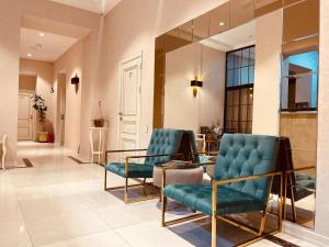 巴库Seven Boutique Hotel Baku的大堂设有2把蓝色椅子和玻璃桌