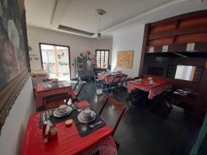 卡波布里奥POUSADA BEIRUTE的一间用餐室,在房间内配有红色的桌子和椅子