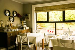 克利夫登本布林之家住宿加早餐旅馆的一间带桌椅的用餐室和窗户。