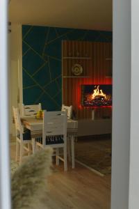 斯库台Denis Comfort Apartment的一间带桌子和壁炉的用餐室