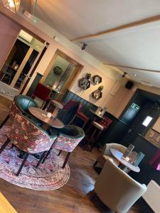 欧克汉普敦The Fountain Inn & Riverside Restaurant的客房设有带桌椅的酒吧。