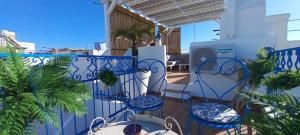 奥良Casa Do Pescador的阳台配有蓝色的桌椅和游泳池。