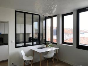 拉罗谢尔Appartement Saint-Nicolas的一间带桌椅和窗户的用餐室