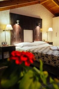 纳夫普利翁亚历山德罗精品酒店的一间卧室,前方有一张红色鲜花的床