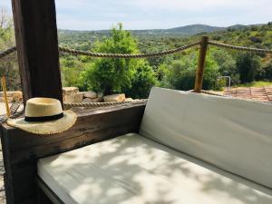 埃斯托伊Villa Monte da Alfarrobeira的坐在长凳上的草帽,享有美景