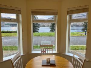 威廉堡Corran, Glenloch View, Fort William 2-Bedroom Loch Side Flat的窗户间里的桌椅