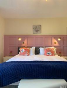 KilfenoraBurrowlodge的一间卧室配有一张大床和紫色床头板