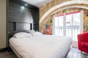波尔多普拉斯德拉波尔斯公寓的卧室设有一张白色大床和一扇窗户。