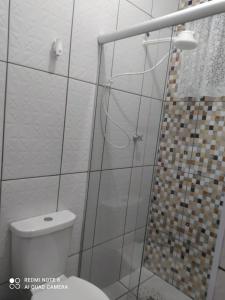 阿帕雷西达Pousada Quarto com ventilador,ar frigobar e garagem的一间带卫生间和玻璃淋浴间的浴室