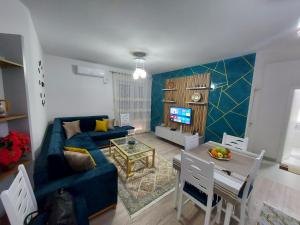 斯库台Denis Comfort Apartment的客厅配有蓝色的沙发和桌子