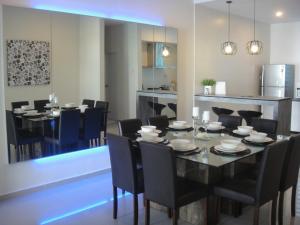 峇都丁宜峇都丁宜槟城三叶草海滩别墅酒店的一间用餐室,配有黑色的桌子和椅子