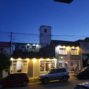 Veintiocho de NoviembreHotel Posada Las Lengas的停在建筑物前面的白色卡车,有灯