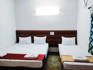 钦奈Royal Green Residency Chennai Airport的白色墙壁客房的两张床