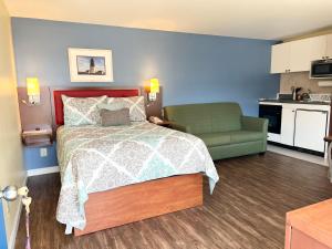 纳拉甘西特斯卡伯勒海滩汽车旅馆的一间卧室配有一张床和一张绿色沙发