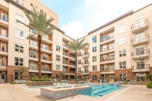 休斯顿RENU at Downtown Houston的公寓大楼设有游泳池和棕榈树