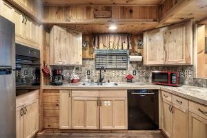 加特林堡Bluebearry Patch的厨房配有木制橱柜、水槽和微波炉