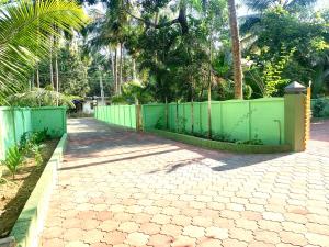 古鲁瓦尤尔Airavatham Apartments的走道前的绿色围栏