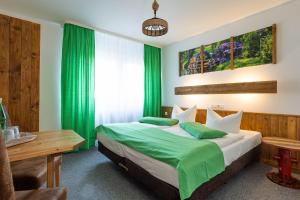 吕本瑙Die GURKENSCHEUNE - Frühstückspension的一间卧室配有一张带绿色床单的床和一张书桌