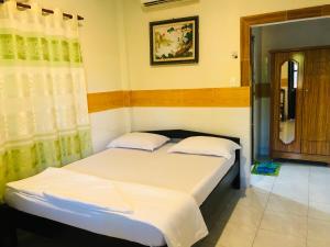 美奈Hoang Nga Garden Guesthouse的一间卧室配有带白色床单和枕头的床。