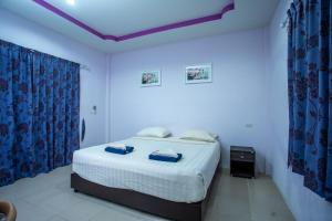 班泰伦格阿伦度假酒店的白色卧室配有蓝色窗帘的床