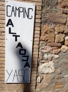Yasocamping yaso-guara的砖墙边的标志