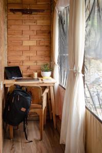 比姆塔尔DugDug Camps的客房配有带笔记本电脑和袋子的书桌