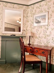 考斯罗斯赛别墅酒店的一张桌子,一张桌子,一张镜子和椅子