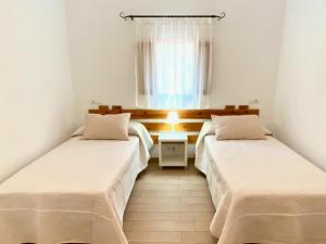 埃斯卡洛Campanitx Villas - Astbury Formentera的带窗户的客房内的两张床