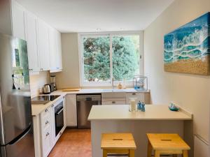 松塞拉德马里纳Villa BEACH&OCEAN的厨房配有白色橱柜和窗户。