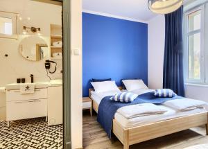 索波特Imperial Apartments - Małe Morze的一间蓝色卧室,配有一张床和镜子
