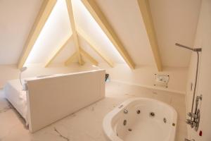 阿马尔菲劳拉别墅酒店的客房内的浴室设有大型白色浴缸