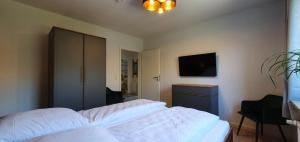 布雷茨特Vogelkoje - Urlaub an der Nordsee in Nordfriesland的卧室配有白色的床和电视